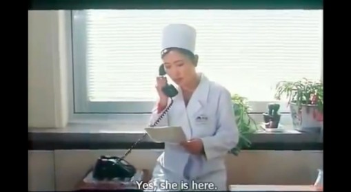 Šiaurės Korėjos filmo kadras: daktarė kalba senu telefonu
