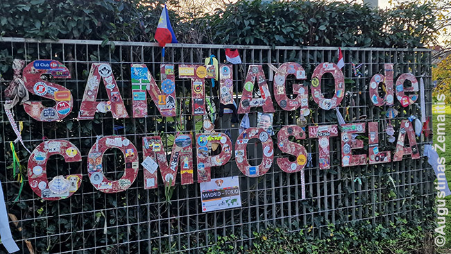 Santiago De Kompostelos įvažiavimas, apkaišytas piligrimų žinutėmis ir simboliais: čia dar pėsti eina tik jie, bet netrukus tai pasikeičia