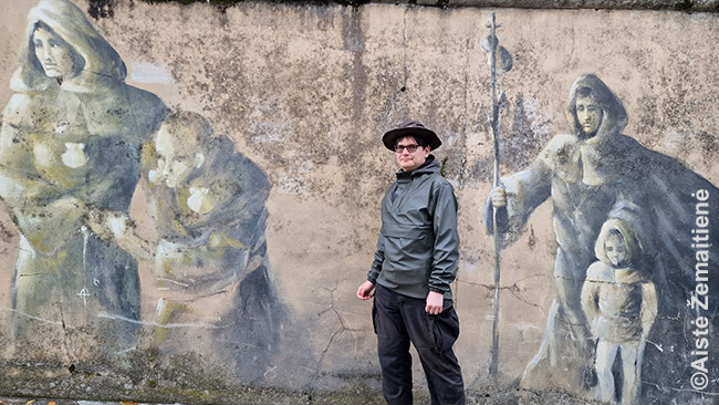 Aš, šiuolaikinis piligrimas, priešais freskas su Viduramžių piligrimais kelio pašonėje