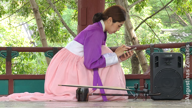 Korėjos liaudies kaimo muzikantė išmaniuoju telefonu reguliuoja garso įrangą - kam tas mikserinis pultas?