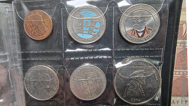 Monetos albume. Kai kurios Panamos monetos netradiciškai spalvingos.
