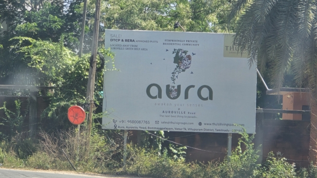 Aura namų reklama prie Aurovilio